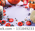 Halloween purple frame background flatlay with pumpkins and party decor 131849233