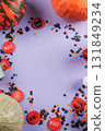 Halloween purple frame background flatlay with pumpkins and party decor 131849234