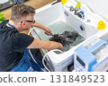 Professional groomer washing black dog in pet spa bath 131849523