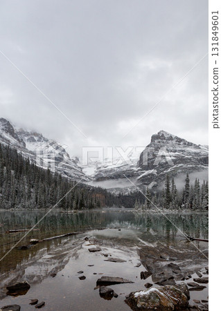 Quiet winter scenery of snowy mountains and lake_Vertical 131849601