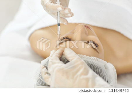 Cosmetologist making rejuvenation anti wrinkle injection in woman face skin in a beauty spa salon. 131849723