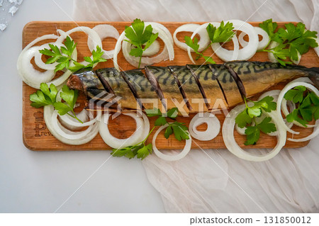 Top view of a festive holiday table with a plate of herring garnished with onion rings. Cozy Christmas, New Year, or Thanksgiving family celebration with traditional holiday appetizers. 131850012