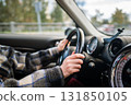 Closeup of woman hands holding steering wheel driving car, drives through the countryside.  131850105