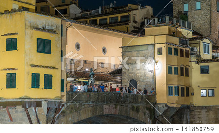 Famous Ponte Vecchio bridge over the Arno river timelapse in Florence, Italy, lit up at night 131850759