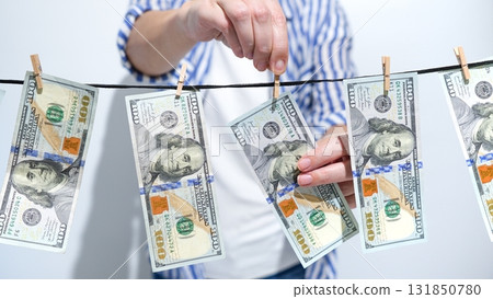 Money Laundering Concept Person Hanging Hundred Dollar Bills on Clothesline to Dry. Finance Theme 131850780