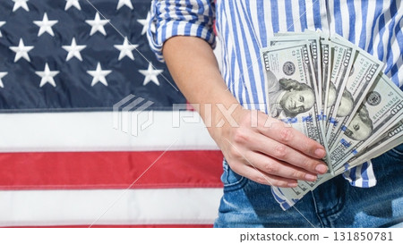 Financial Freedom Concept Woman Holding US Currency Against American Flag Backdrop Financial Freedom Concept Woman Holding US Currency Against American Flag Backdrop 131850781