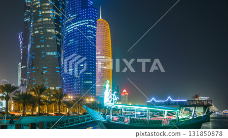 Traditional dhow boat in Doha at night timelapse, with modern buildings in the background. 131850878