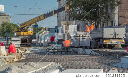Loader crane for loading and unloading sleepers from truck which stands on a road construction site aerial timelapse Loader crane for loading and unloading sleepers from truck which stands on a road construction site aerial timelapse 131851125