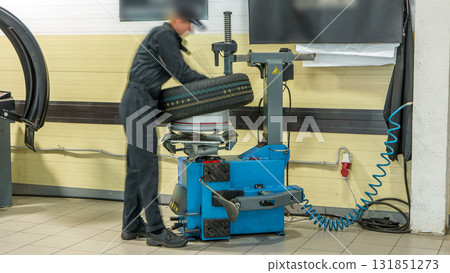 Professional car mechanic replace tire on wheel in auto repair service timelapse. 131851273