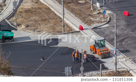 Construction site of avenue with asphalt paver, roller and truck aerial timelapse. Construction site of avenue with asphalt paver, roller and truck aerial timelapse. 131851306