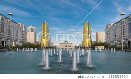 A square in front of Ak Orda with yellow towers timelapse hyperlapse and fountain in the foreground. A square in front of Ak Orda with yellow towers timelapse hyperlapse and fountain in the foreground. 131851364