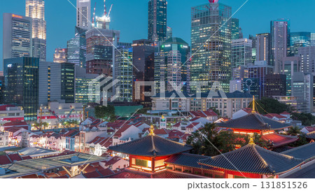 The Buddha Tooth Relic Temple comes alive at night in Singapore Chinatown day to night timelapse, with the city skyline in the background. The Buddha Tooth Relic Temple comes alive at night in Singapore Chinatown day to night timelapse, with the city skyline in the background. 131851526
