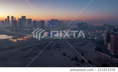 Abu Dhabi city skyline with skyscrapers before sunrise from above night to day timelapse Abu Dhabi city skyline with skyscrapers before sunrise from above night to day timelapse 131851559