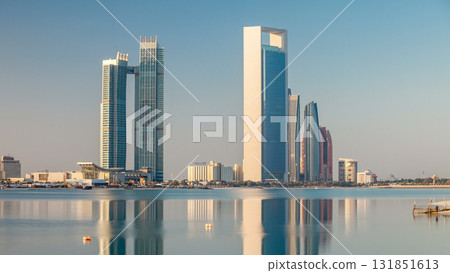 Abu Dhabi city skyline with skyscrapers after sunrise with water reflection timelapse Abu Dhabi city skyline with skyscrapers after sunrise with water reflection timelapse 131851613