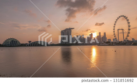 Sunset over the downtown skyline of Singapore as viewed from across the water from The Garden East timelapse. Singapore. Sunset over the downtown skyline of Singapore as viewed from across the water from The Garden East timelapse. Singapore. 131851692