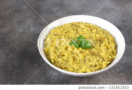 Indian khichri, kichri with rice, lentils and spices on grey background. Top view. Ayurvedic diet. Indian khichri, kichri with rice, lentils and spices on grey background. Top view. Ayurvedic diet. 131851853