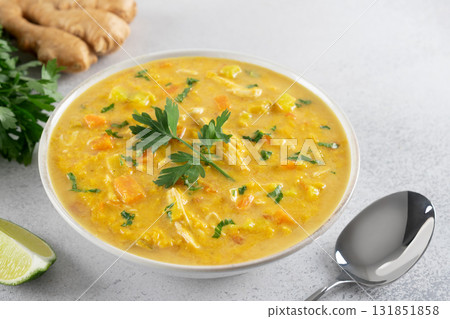 Traditional Indian Mulligatawny soup with lentils and chicken on a dark background. Top view. Traditional Indian Mulligatawny soup with lentils and chicken on a dark background. Top view. 131851858