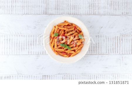Italian pasta arrabbiata with tomato sauce, chili pepper, parmesan on wooden background. Top view Italian pasta arrabbiata with tomato sauce, chili pepper, parmesan on wooden background. Top view 131851871