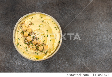 Lupin hummus or turmeric hummus with olive oil and herbs on a gray background. Top view. copy space. Lupin hummus or turmeric hummus with olive oil and herbs on a gray background. Top view. copy space. 131851872
