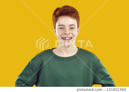 Portrait close-up of happy, red-haired, confident teenager dressed in warm green sweater and looking straight into the camera. Portrait close-up of happy, red-haired, confident teenager dressed in warm green sweater and looking straight into the camera. 131852369