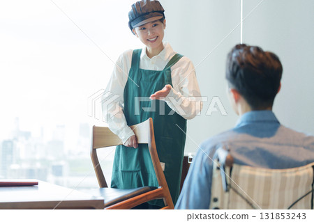 咖啡館工作人員引導一位坐輪椅的男子 咖啡館工作人員引導一位坐輪椅的男子 131853243