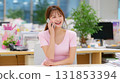 辦公室裡微笑的年輕女士接到電話 131853394