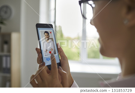 Closeup woman using phone with online dating application to search and find love Closeup woman using phone with online dating application to search and find love 131853729