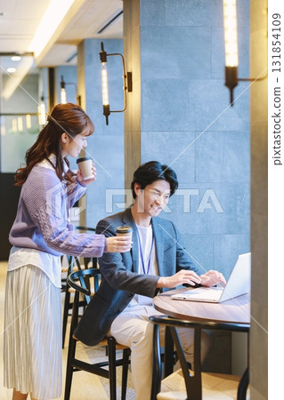 A woman recommending coffee to a colleague in the office A woman recommending coffee to a colleague in the office 131854109