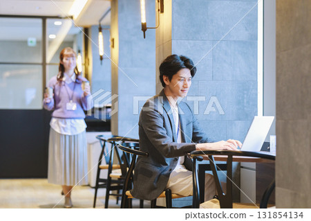 辦公室裡，一位女士為一位男同事端咖啡 131854134