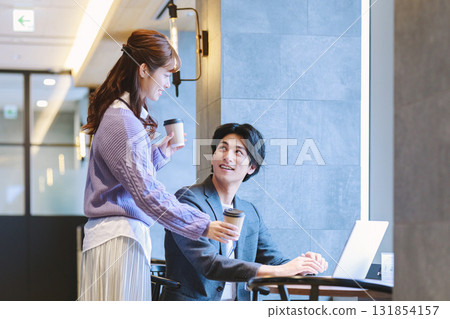 A woman recommending coffee to a colleague in the office 131854157