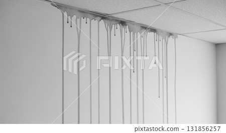 Severe water damage with long streaks running down a white wall from a leaking ceiling 131856257