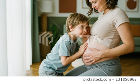 Curious young boy listening to his pregnant mother belly, anticipating new sibling 131856962