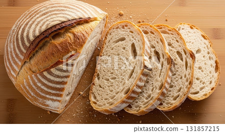 Artisanal sourdough bread loaf, freshly baked and sliced on a rustic wooden board 131857215