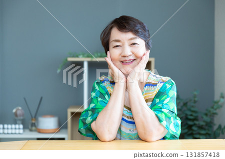 Senior woman smiling with a relaxed expression, hands on cheeks, upper body Senior woman smiling with a relaxed expression, hands on cheeks, upper body 131857418