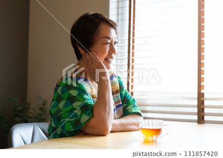 Senior woman chatting with a relaxed expression, hands on cheeks, upper body Senior woman chatting with a relaxed expression, hands on cheeks, upper body 131857420