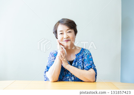 Senior woman smiling with a relaxed expression, hands on cheeks, upper body 131857423