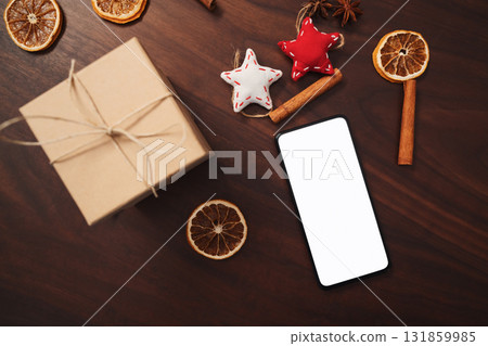 flat lay with smarthone and christmas decorations on walnut table flat lay with smarthone and christmas decorations on walnut table 131859985