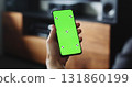 man holding smartphone with green screen near tv stand 131860199