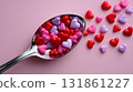 Top down view of a silver teaspoon overflowing with red and pink heart shaped candy pieces 131861227