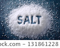 Top view of coarse white salt fully covering a background surface with the word SALT written clearly on the granular surface 131861228