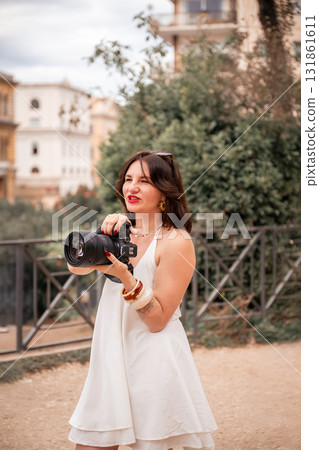 Smiling woman photographer holding professional camera outdoors 131861611