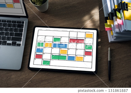showing a monthly calendar with color coded time blocking on a wooden desk, ideal for planning schedules, appointments, projects, and home office productivity. showing a monthly calendar with color coded time blocking on a wooden desk, ideal for planning schedules, appointments, projects, and home office productivity. 131861887