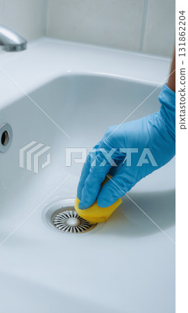 Hand scrubbing sink drain with yellow sponge in a bathroom Hand scrubbing sink drain with yellow sponge in a bathroom 131862204