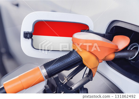 The flag of Indonesia on the lid of the gas tank of a car at a gas station in close-up. High or low gasoline prices at Indonesian gas stations. Problems with the quality of gasoline and diesel fuel The flag of Indonesia on the lid of the gas tank of a car at a gas station in close-up. High or low gasoline prices at Indonesian gas stations. Problems with the quality of gasoline and diesel fuel 131862492