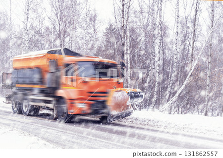 Orange-colored snow removal equipment removes snow on roads and country roads in winter during heavy snowfall. Heavy road conditions and ice . Safety and accidents on the roads. Orange-colored snow removal equipment removes snow on roads and country roads in winter during heavy snowfall. Heavy road conditions and ice . Safety and accidents on the roads. 131862557