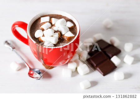 Hot chocolate in red cup on white wooden table background. Hot chocolate in red cup on white wooden table background. 131862882