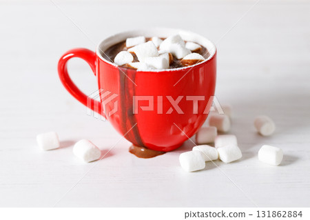 Hot chocolate in red cup on white wooden table background. Hot chocolate in red cup on white wooden table background. 131862884