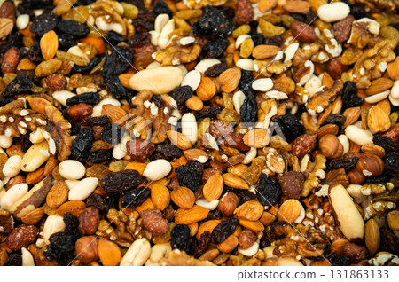 Pile of nuts and dried fruit for a snack. Bulk snacks at the store for a healthy and nutritious meal, close-up as a background Pile of nuts and dried fruit for a snack. Bulk snacks at the store for a healthy and nutritious meal, close-up as a background 131863133