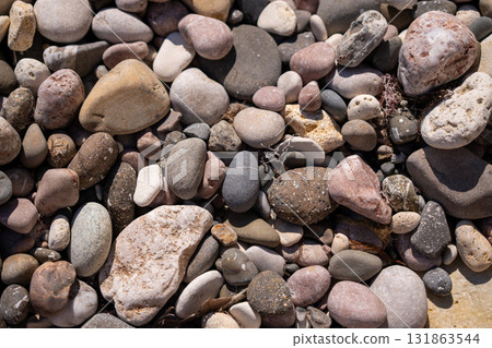 Pebbles, stones, beach. Rounded pebbles and stones covering a beach surface, creating a natural tranquil backdrop Pebbles, stones, beach. Rounded pebbles and stones covering a beach surface, creating a natural tranquil backdrop 131863544