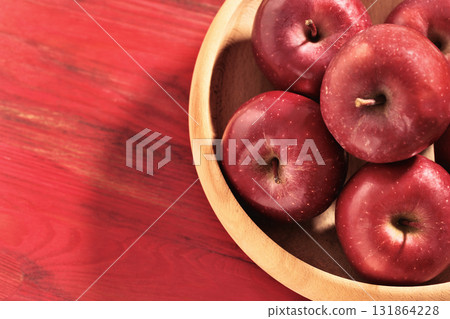 Red apples in wooden plate 131864228